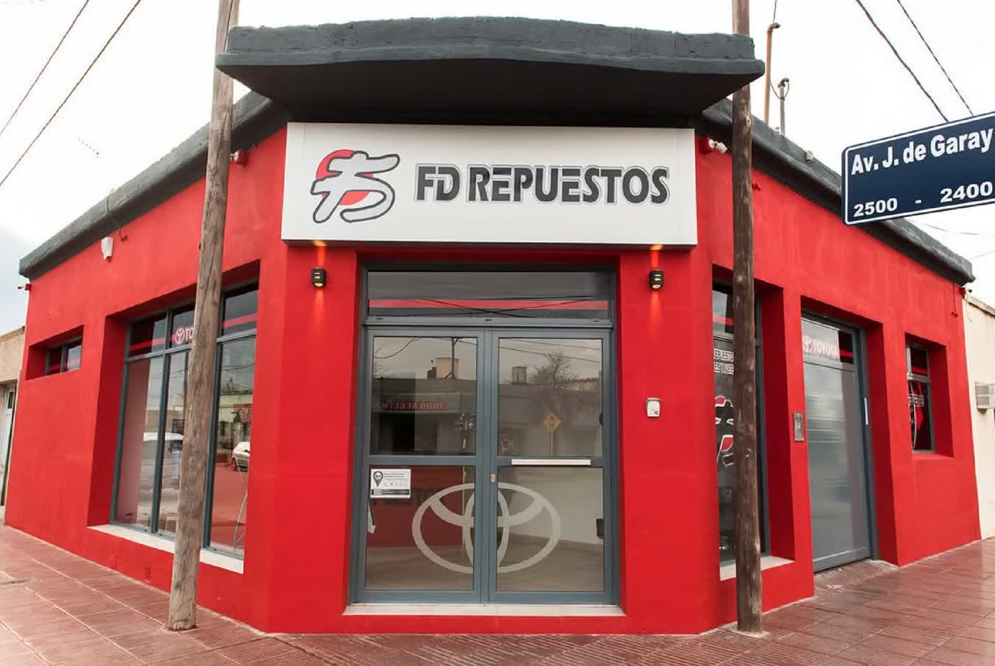Frente del local de FD Repuestos, pintado de rojo, en la esquina de Av. Juan de Garay